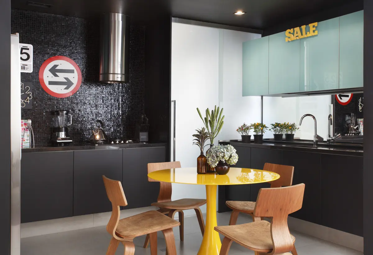 Comedor moderno con mesa redonda amarilla y cocina negra al fondo — proyecto VF House, por Studio Ro-ca