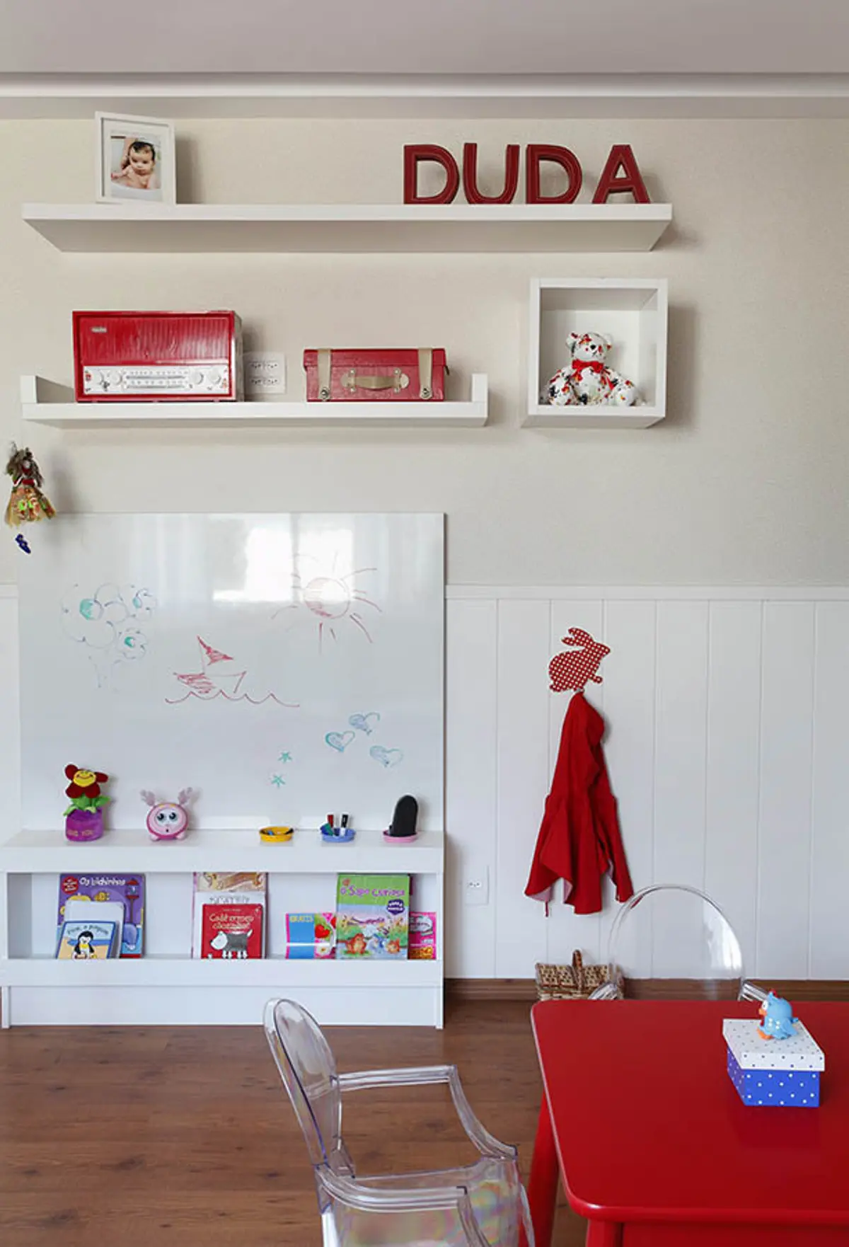 Dormitorio infantil con estantes flotantes rojos, pizarra y perchero decorado — proyecto Casa Barra ED, por Amanda Miranda