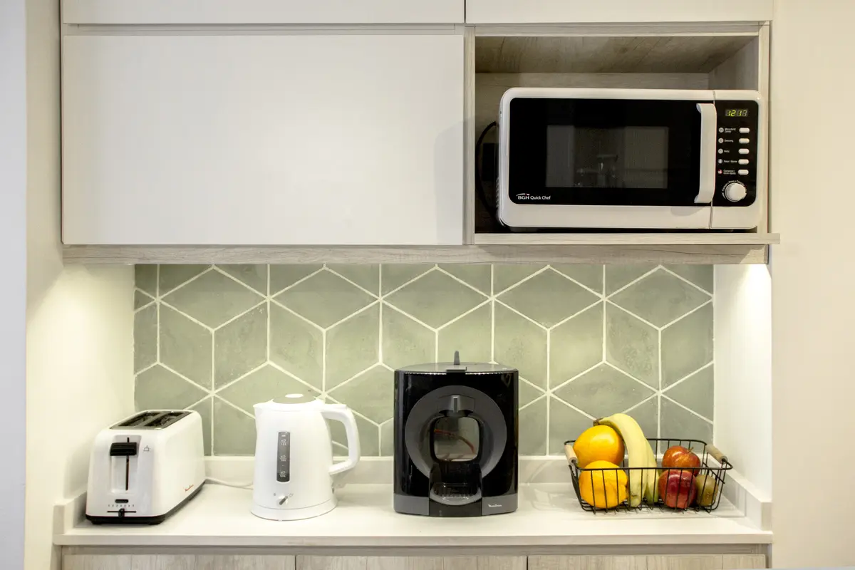 Cocina minimalista con backsplash geométrico verde y electrodomésticos integrados — proyecto Guido, por Fainteriores, en CABA