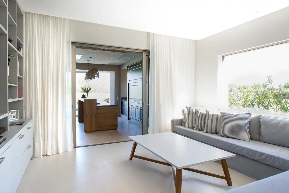 Sala de estar escandinava moderna com cozinha integrada e janelas amplas — projeto Casa DF, por Estudio Junor, em Tigre