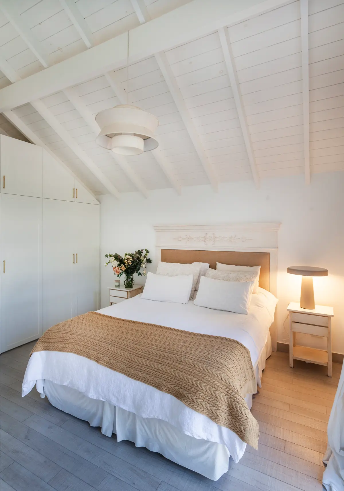 Dormitorio escandinavo con techo inclinado y vigas expuestas — proyecto Highland, por Lala Loviscek arquitecta, en Pilar