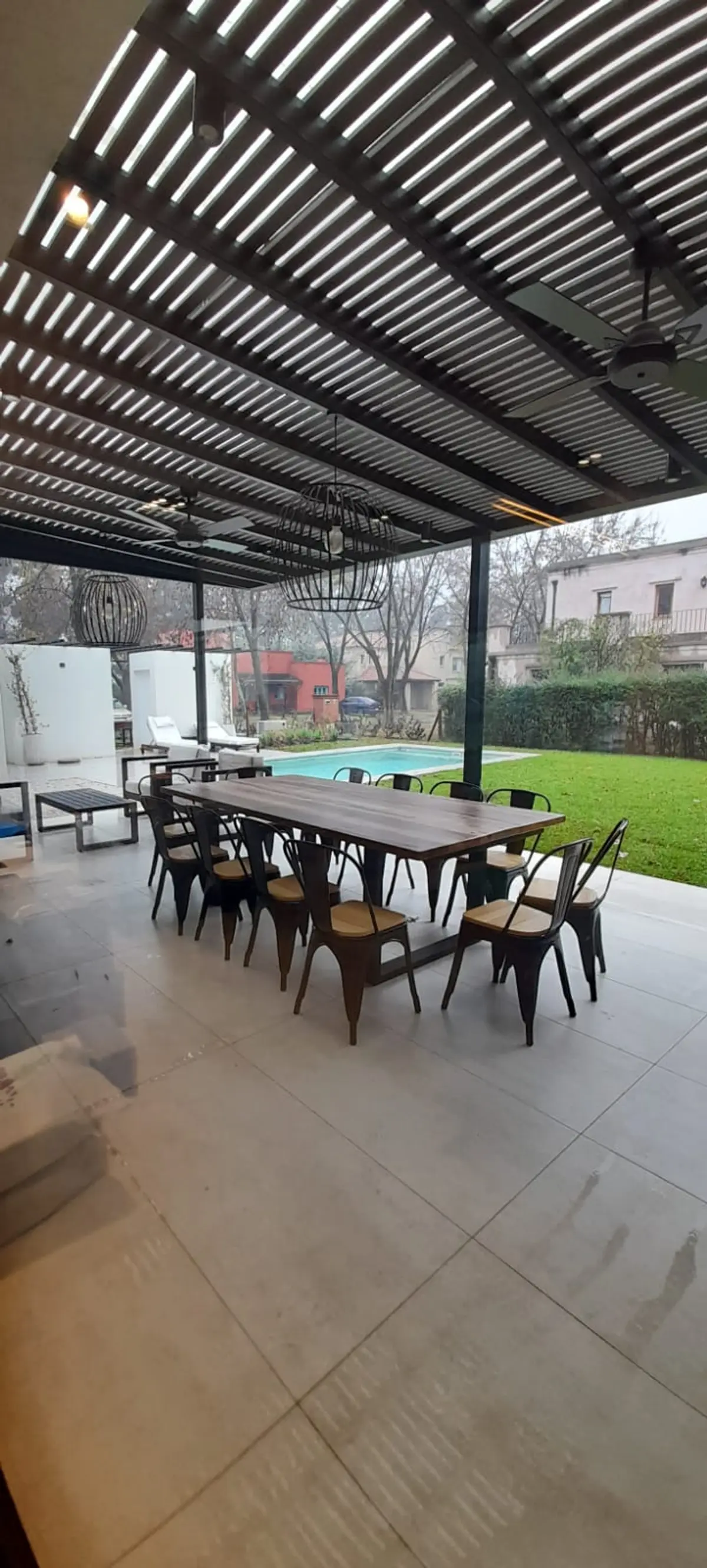 Área externa moderna com pergolado, mesa de jantar e piscina — projeto El 54, por Valeria Damiani Arquitecta, em Pilar