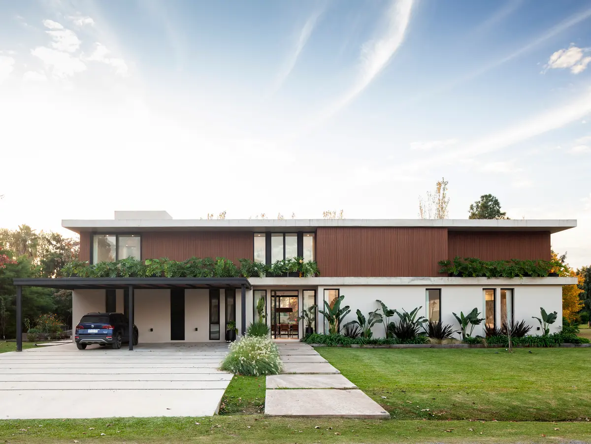 Fachada moderna com painéis de madeira, concreto e grandes janelas — projeto CASA HS143, por A'PRIMA - Arquitectura Sustentable, em km 7.5 Ruta 25