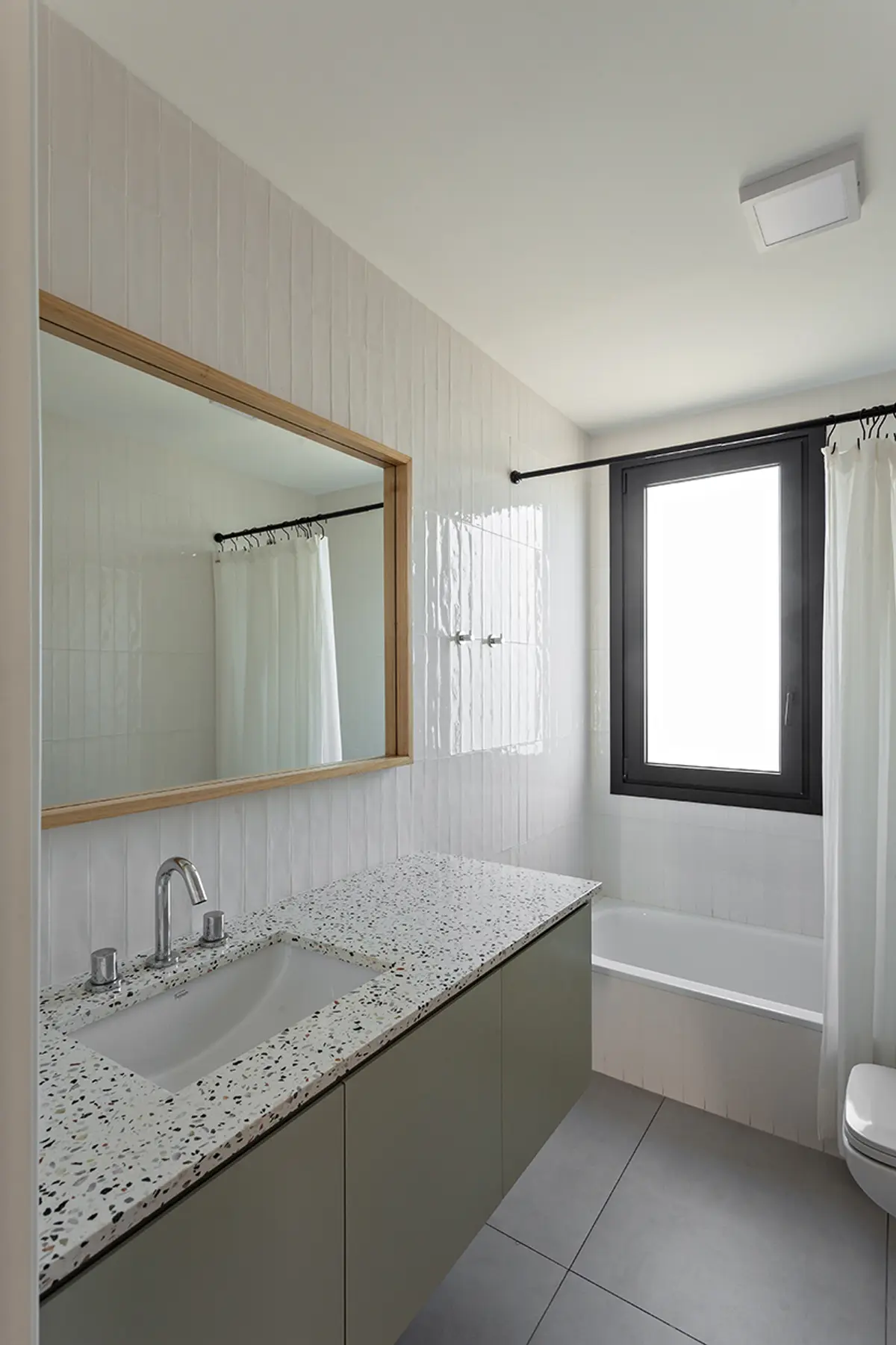 Baño moderno con espejo amplio y encimera de terrazo — proyecto CASA RDV, por Rastro Estudio, en San Isidro