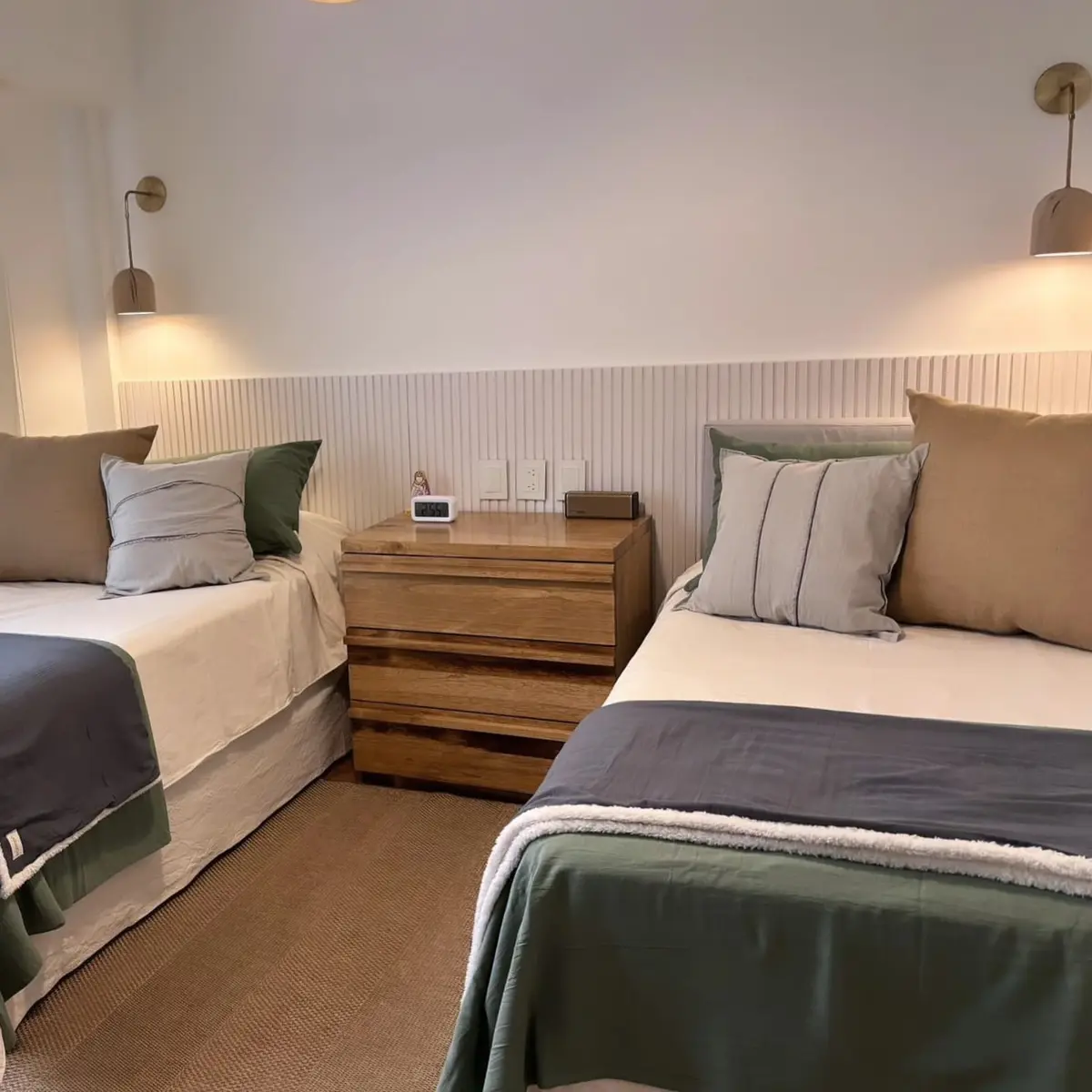 Quarto com duas camas de solteiro, decoração minimalista e luz quente — projeto Uruguay, por Claraboia, em Recoleta