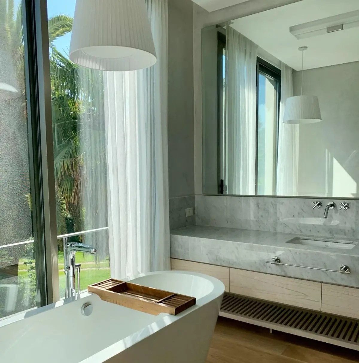 Baño moderno con ventana grande, bañera exenta y mármol — proyecto CASA BECCAR, por Estudio Xime Fontan Balestra, en Béccar
