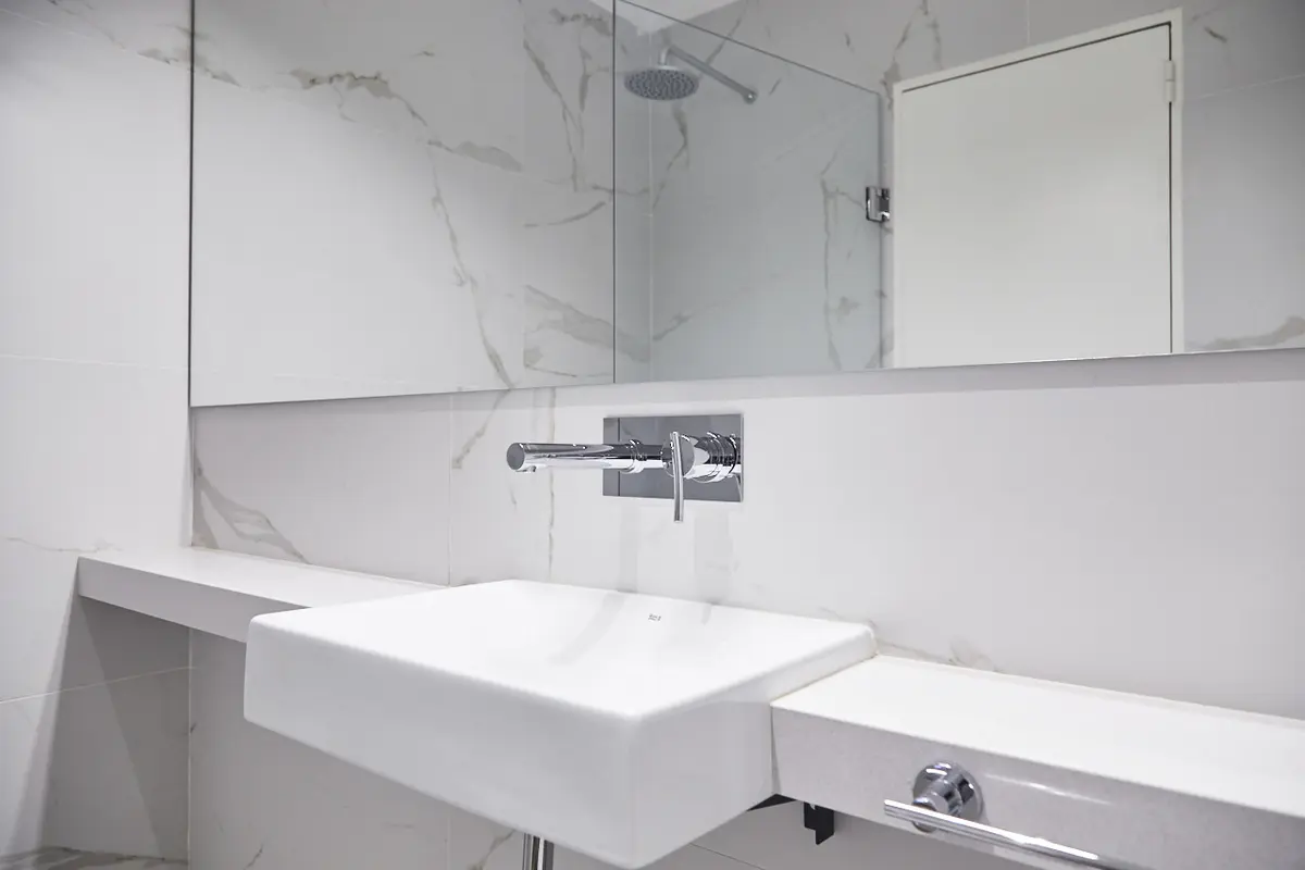 Baño moderno minimalista con bacha de losa y grifería de pared — proyecto UGARTECHE, por Estudio Trama, en Palermo