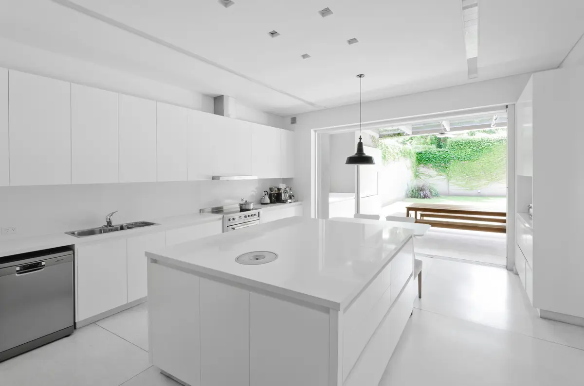 cozinha minimalista branca com ilha grande e jardim — projeto Casa D, por Estudio Dado, em Belgrano