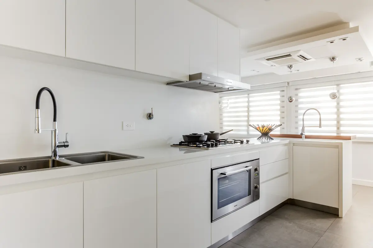 Cozinha moderna minimalista branca com eletrodomésticos embutidos — projeto Piso en Belgrano, por Gutman+Lehrer Arquitectas, em Belgrano