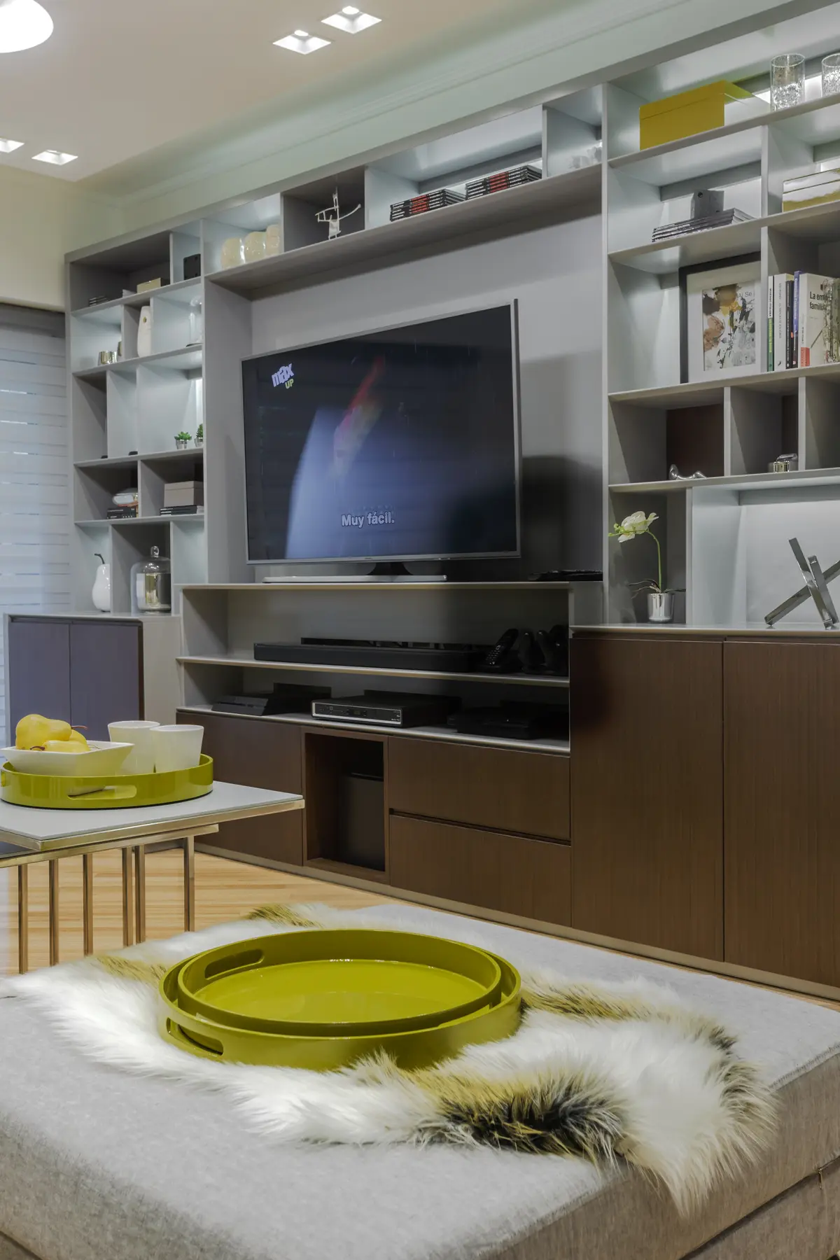 Sala de estar moderna com móveis embutidos e detalhes verdes — projeto Piso en Belgrano III, por Gutman+Lehrer Arquitectas, em Belgrano