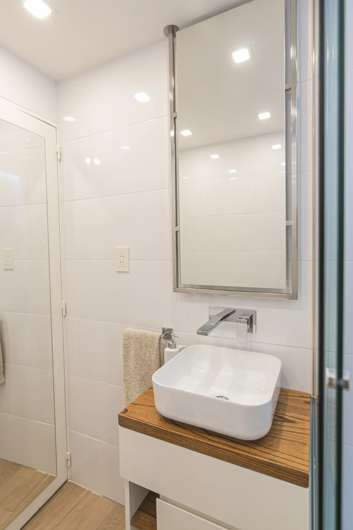 Baño moderno minimalista con mesada de madera y bacha de apoyo — proyecto Austria, por ST Arquitectas, en CABA