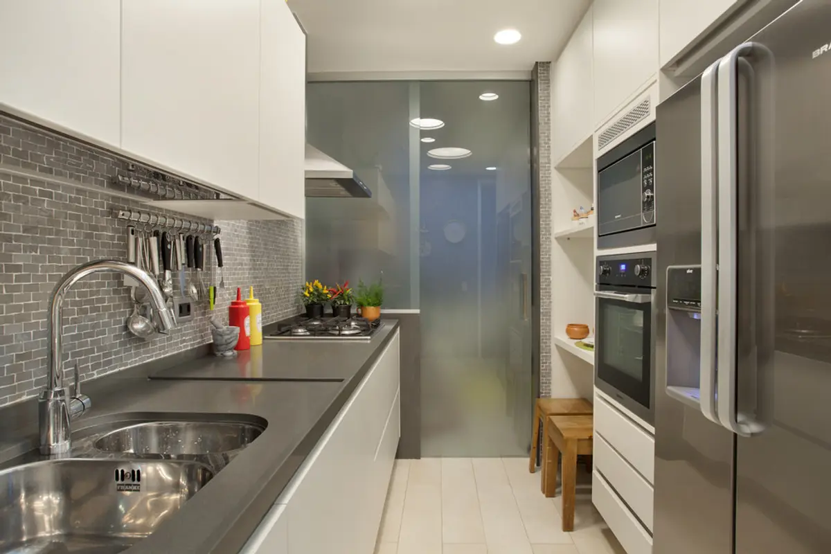 Cocina moderna angosta con mesadas grises, electrodomésticos y vidrio esmerilado — proyecto MS House, por Studio Ro-ca