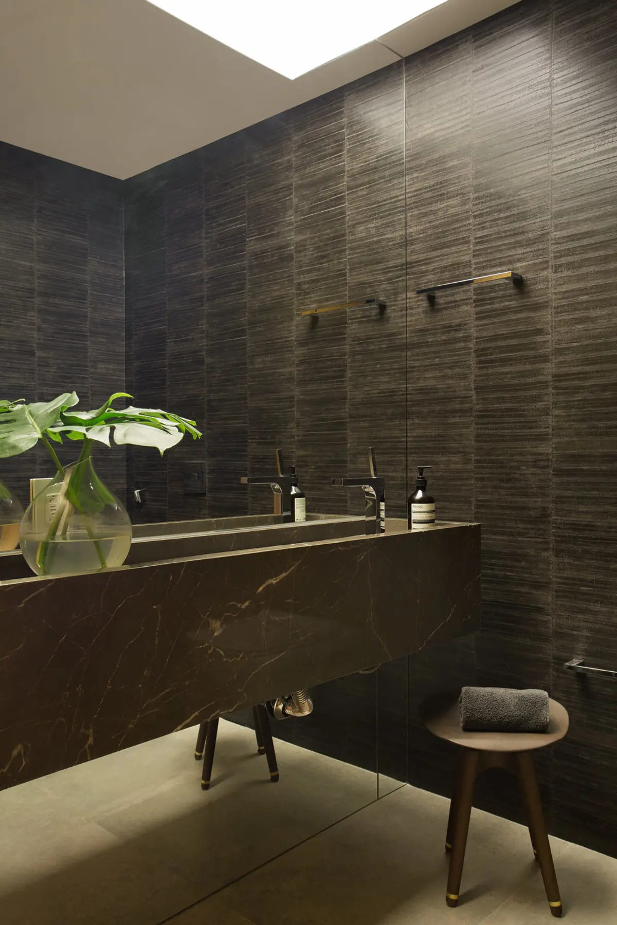 Bano minimalista con mesada marmol negro y azulejos texturados — proyecto PL House, por Studio Ro-ca