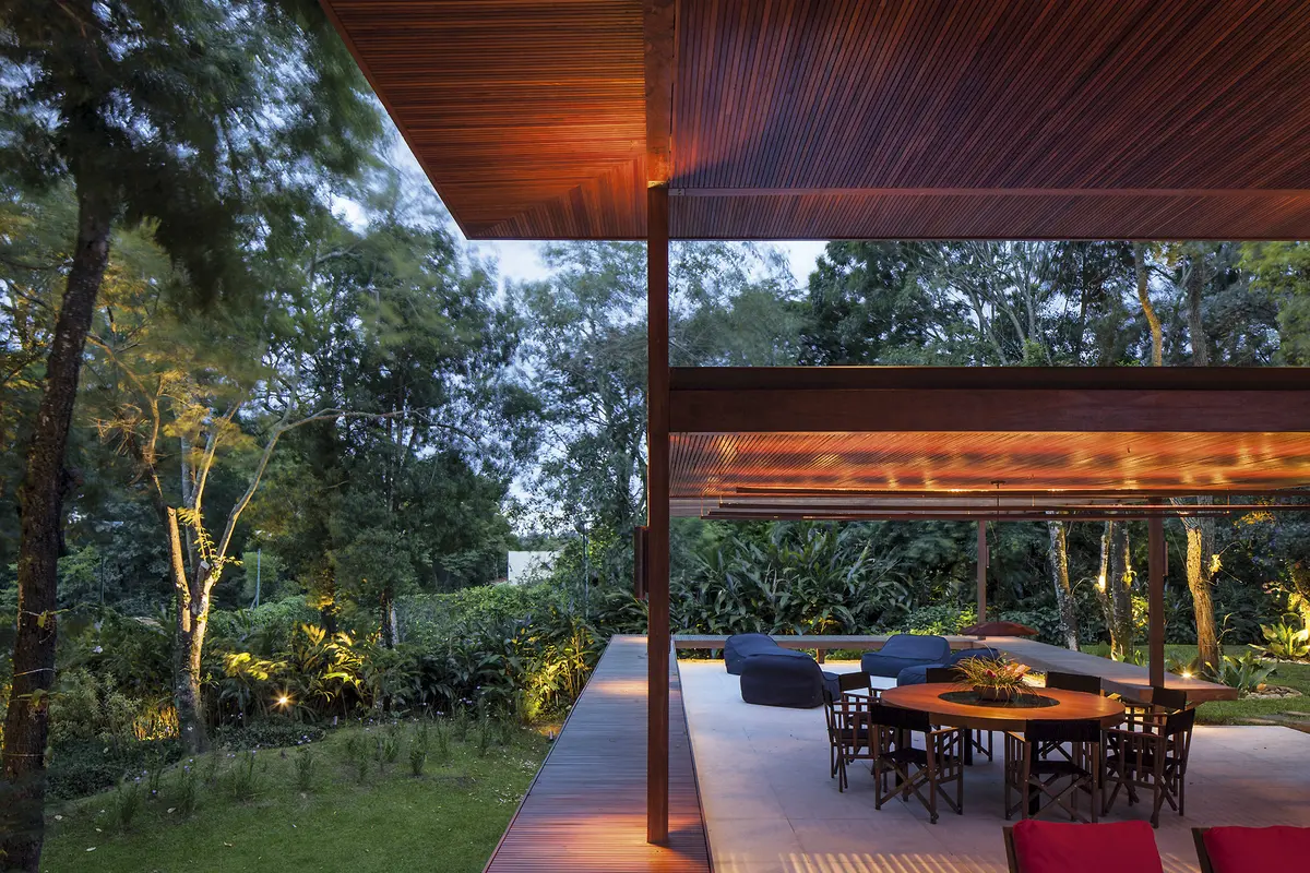Galería moderna con techo de madera y vista al jardín arbolado — proyecto Residência GS, por Gil Fialho