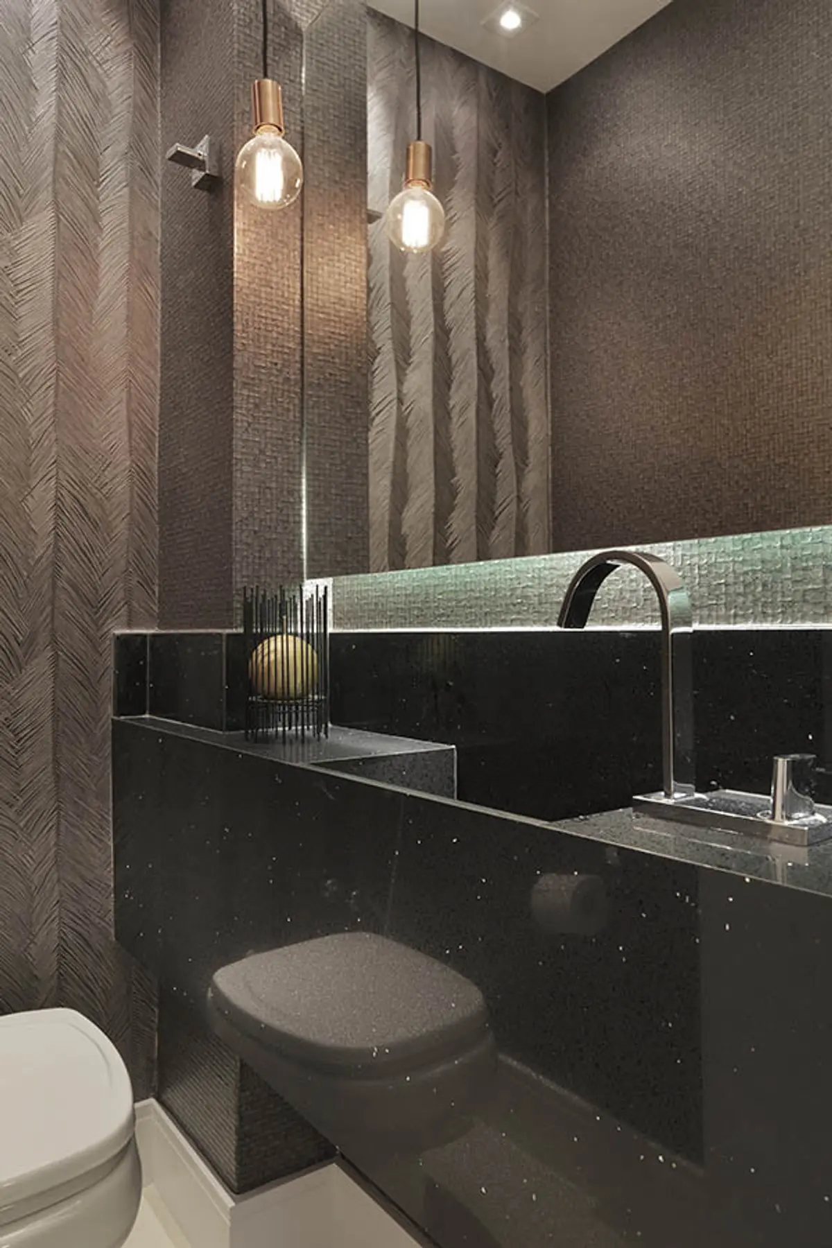 Baño moderno con papel texturado, mesada de piedra y luces industriales — proyecto Apartamento Barra LM, por Amanda Miranda