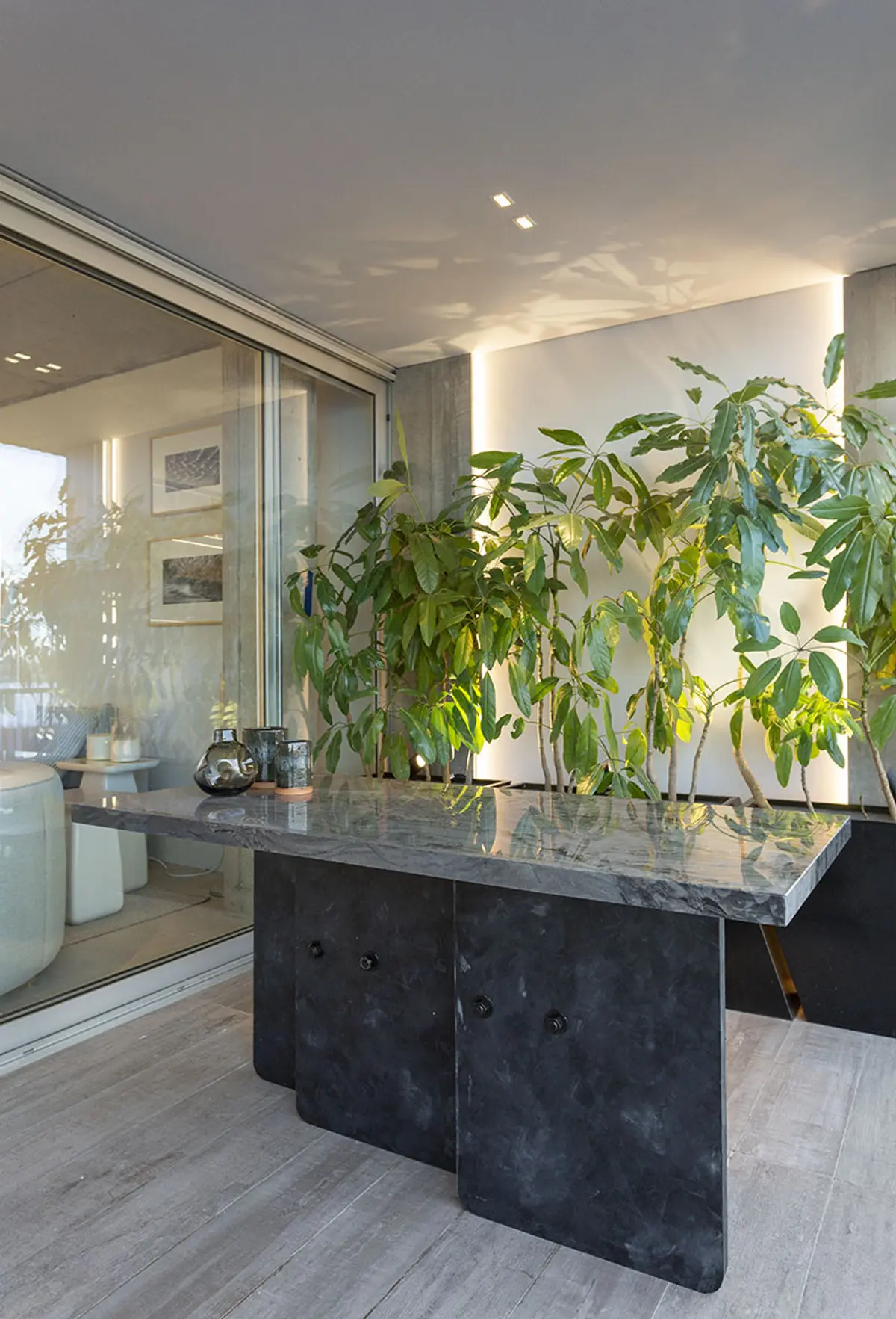Terraza moderna con consola de mármol y plantas exuberantes — proyecto Casa FOA, por Viviana Melamed