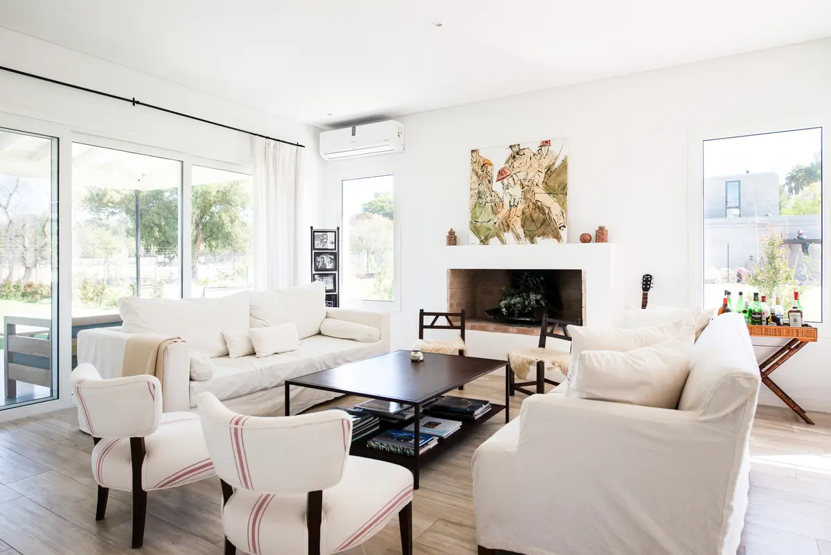 Sala moderna com janelões, sofá branco e lareira integrada — projeto Miradores, por ATO Arquitectos, em Miradores de la Bahia (Bahia Grande Nord