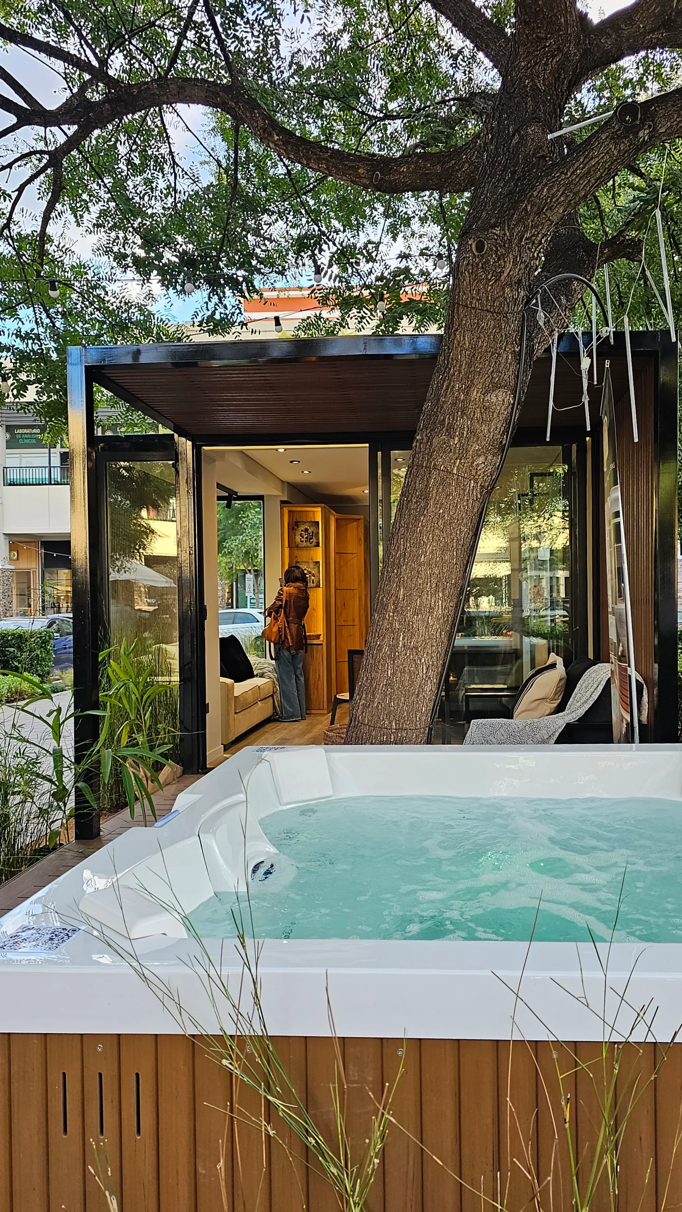 Area de piscina moderna con jacuzzi y árbol integrado