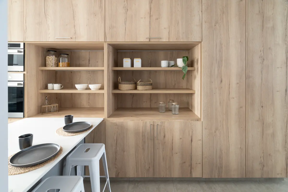 Cozinha escandinava moderna com armários de madeira clara integrados e mesa — projeto OBRA FALUCHO, por Maria Menna Arquitecta