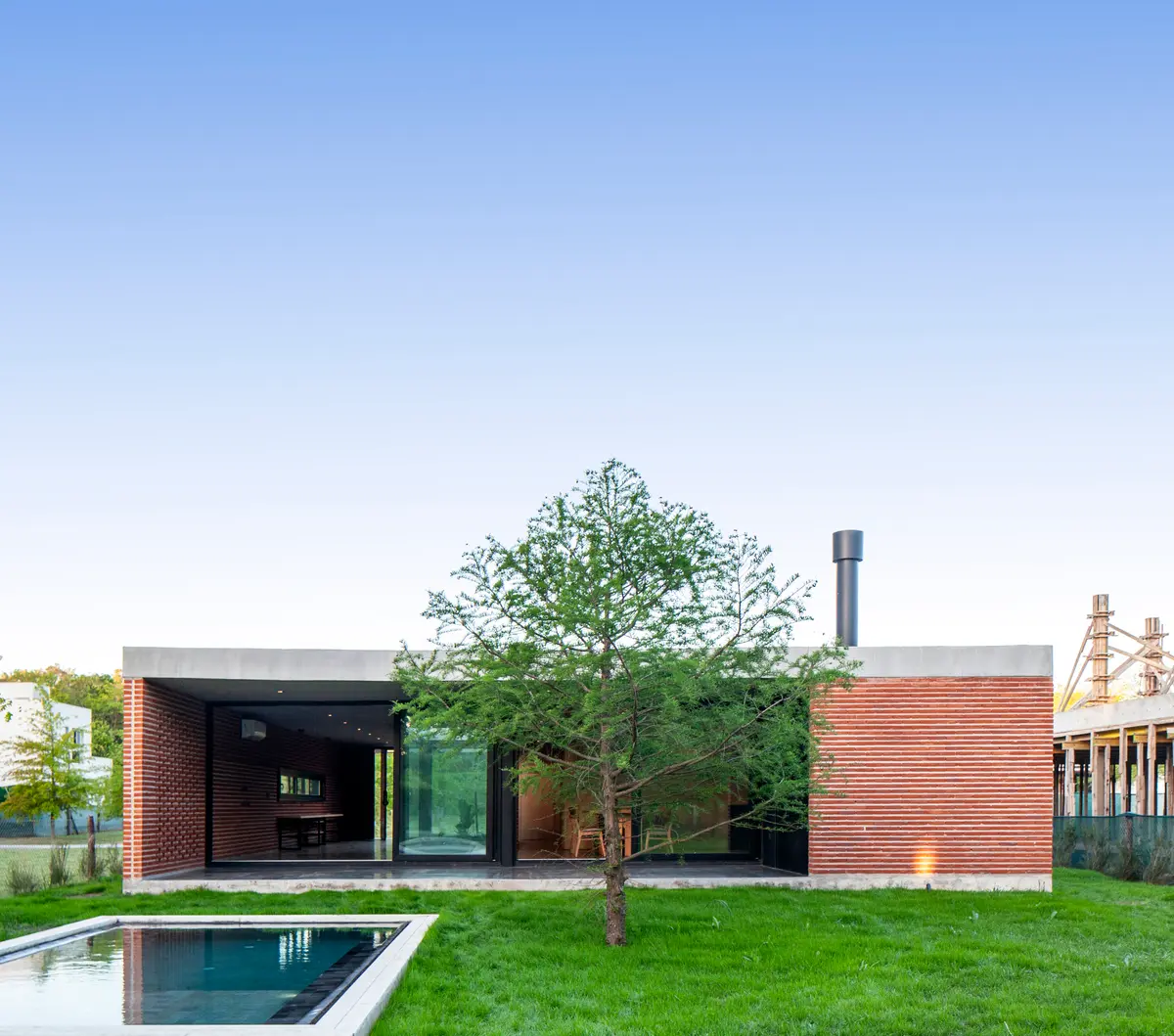 Casa moderna minimalista com fachada de tijolos e piscina — projeto Casa FLOIG, por V2 Arquitectos, em Villa Elisa