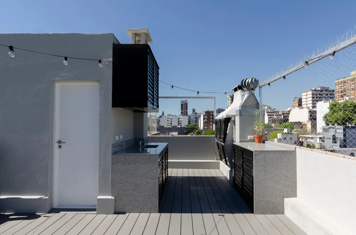 Terraza moderna con cocina exterior y deck de madera — proyecto Juana Azurduy, por Cuarto Estudio