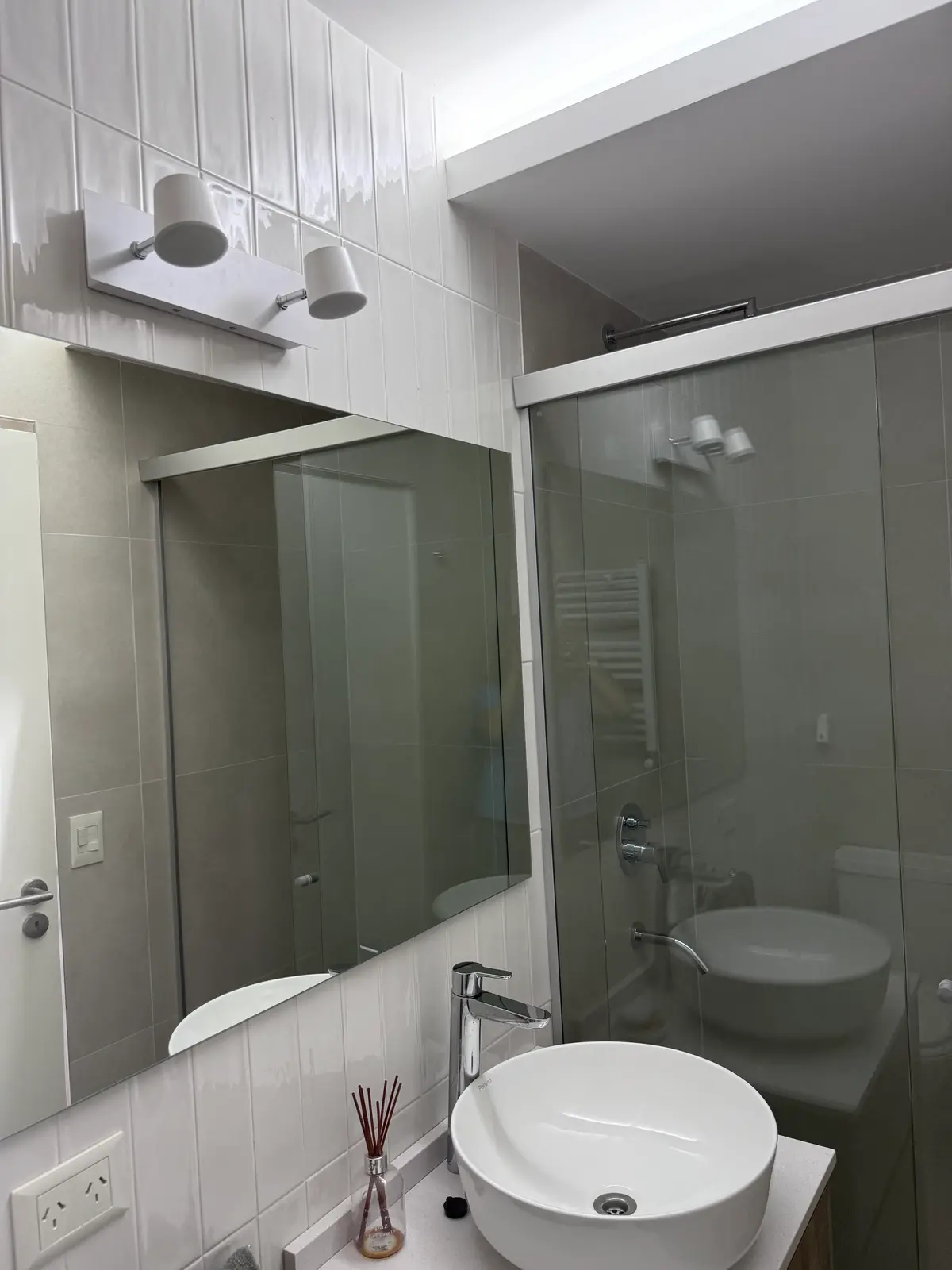 Baño moderno con bacha redonda, espejo grande y luces minimalistas — proyecto PH CASI, por Estudio Grupo 32, en San Isidro