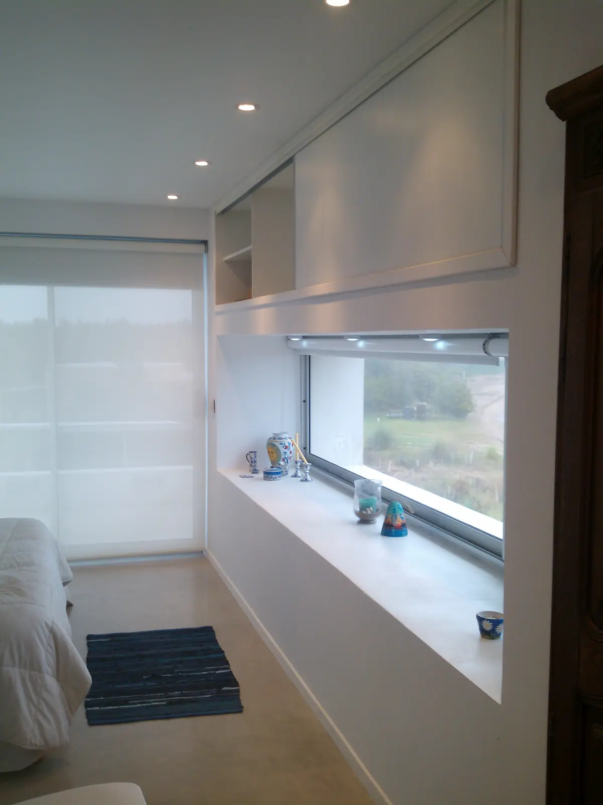 Dormitorio moderno minimalista con cama grande y almacenamiento integrado — proyecto VILLA ESMERALDA, por GJF estudio, en Pinamar