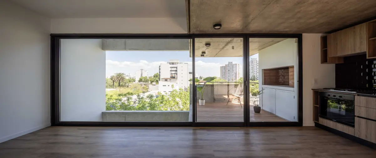 Living moderno con cocina y balcón con parrilla exterior — proyecto Terrazas de Malvinas, por DREI Arquitectura y Desarrollos, en La Plata