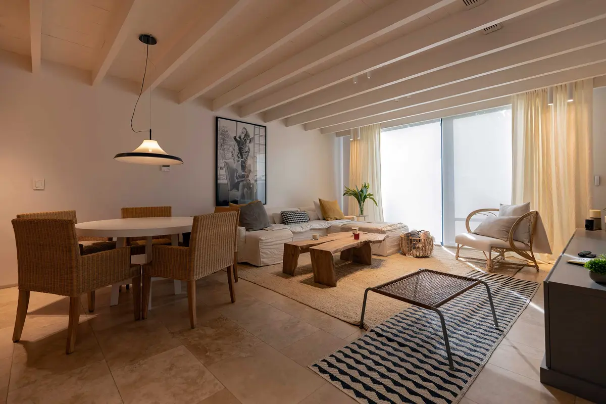 Sala de estar e jantar moderna integrada com vigas de madeira e piso de pedra — projeto Las Marías, por Santiago Cordeyro Arquitectos, em San Isidro