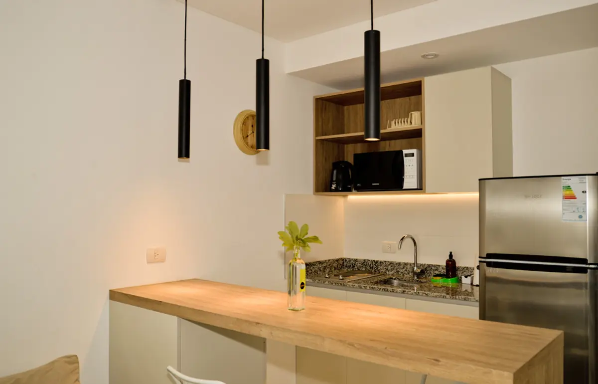 Cocina Con Isla Estilo Industrial con color predominante Beige del Proyecto El Faro por Guille Di Pietro Fotografia