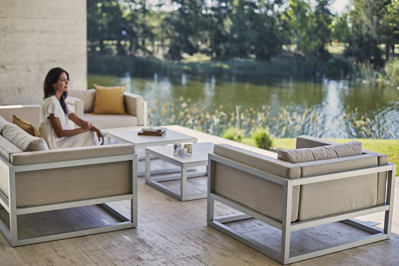 Terraza con vista al río, muebles modernos y jardín de fondo
