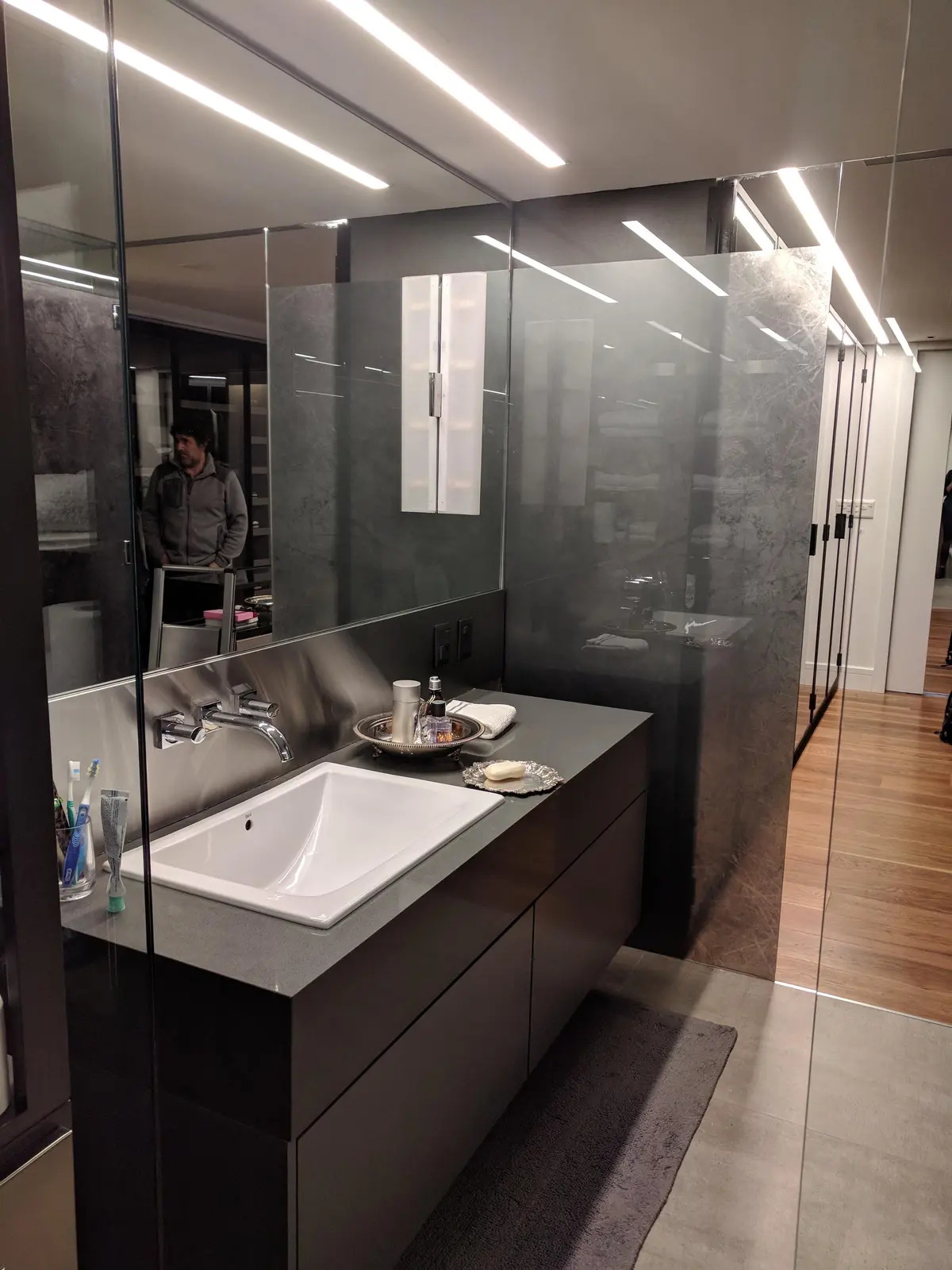 Baño moderno con bacha blanca rectangular, mesada de piedra gris y mueble oscuro — proyecto AT - Departamento en Palermo, por MLS Estudio, en Palermo