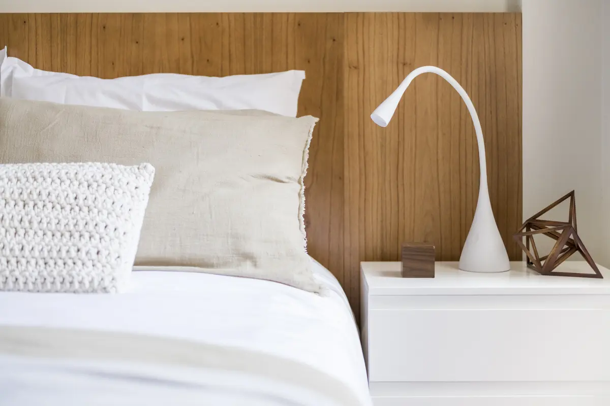Dormitorio moderno con detalles en madera y lámpara curva — proyecto Mansilla, por Estudio Basa, en CABA