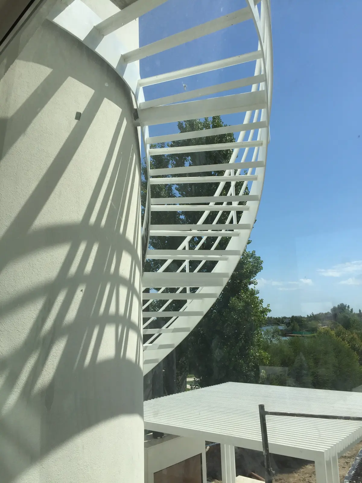 Escalera caracol moderna con sombras, espacio exterior — proyecto CASA LAGUNA, por Estudio Xime Fontan Balestra, en Tigre