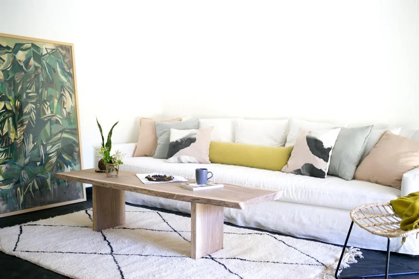 Living moderno con sofá blanco y mesa de madera.