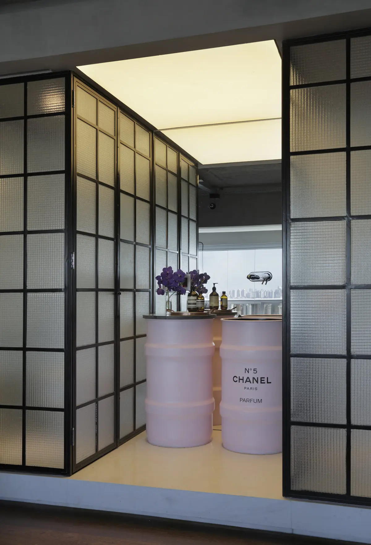 Boutique Chanel con puertas vidriadas, botellas de perfume y vista urbana — proyecto RA Loft, por Studio Ro-ca