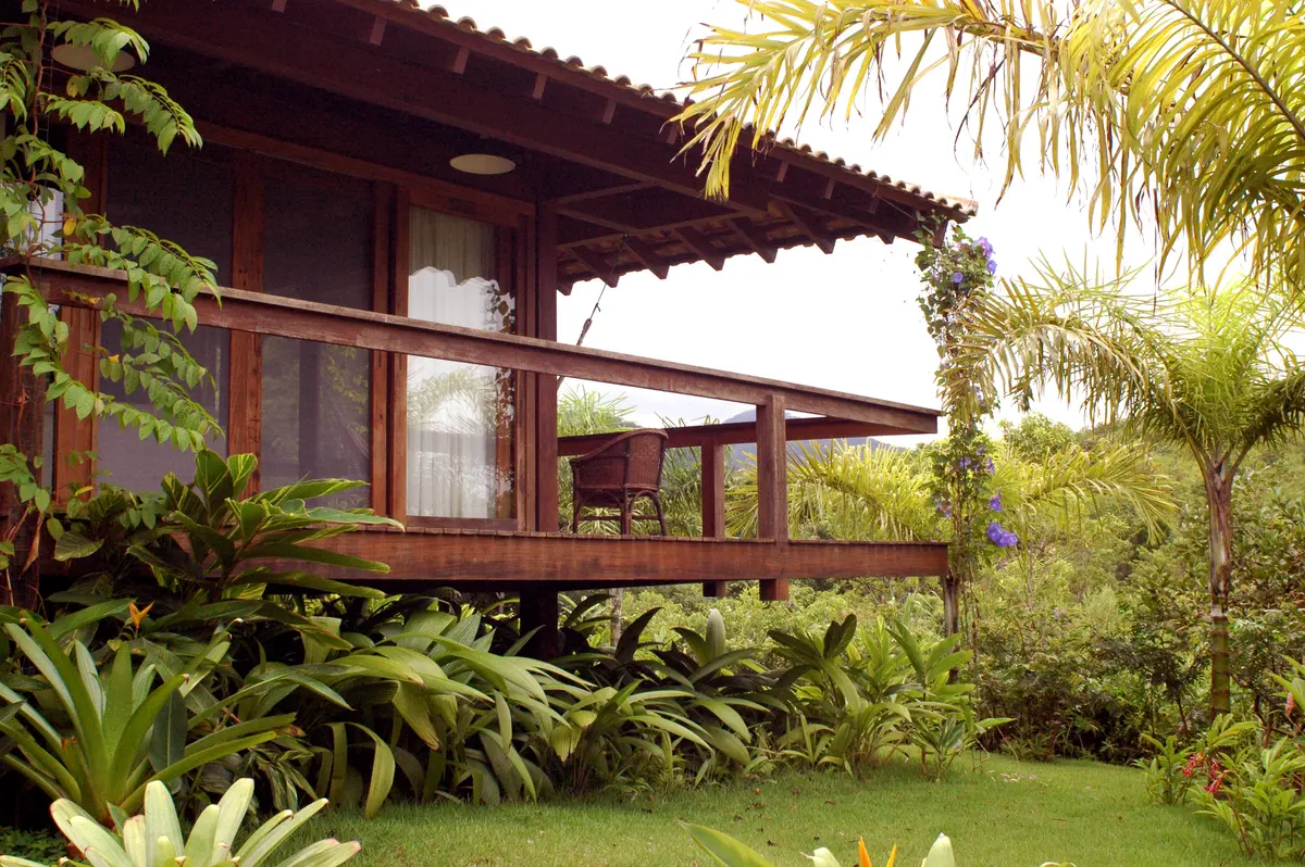Galería de madera con vista al jardín tropical y palmeras — proyecto Fazenda Indaiauba, por Gil Fialho