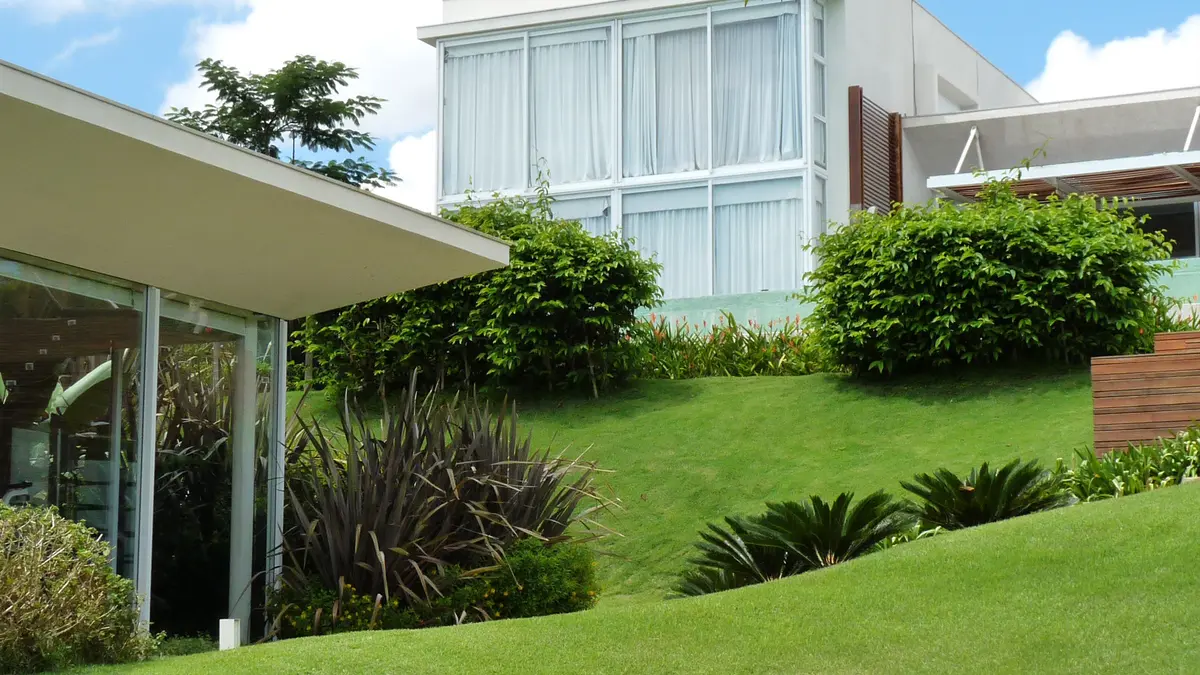 Jardín moderno con césped, plantas y galería con pérgola — proyecto Residência NK, por Gil Fialho