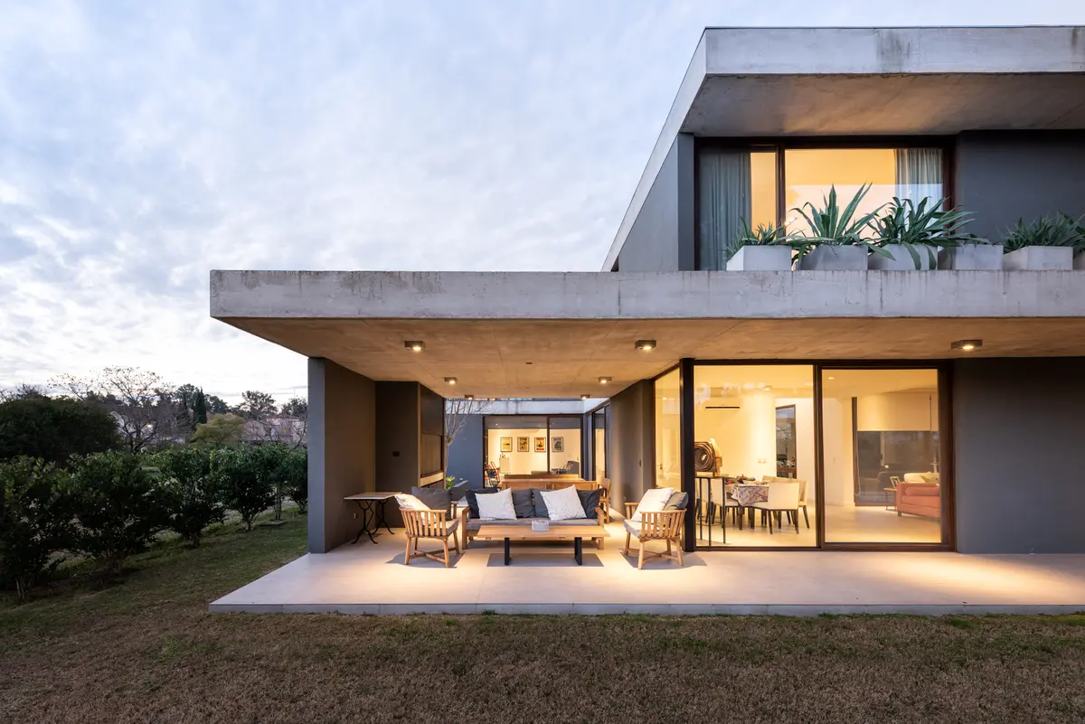 Fachada moderna com varanda em concreto e sala de estar externa — projeto Casa TDN, por BDB Arquitectos
