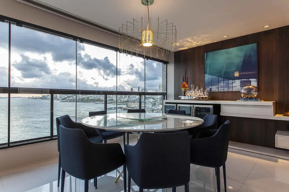 Comedor moderno con vista panorámica al mar, mesa redonda vidrio — proyecto Varandas, por Xico Diniz