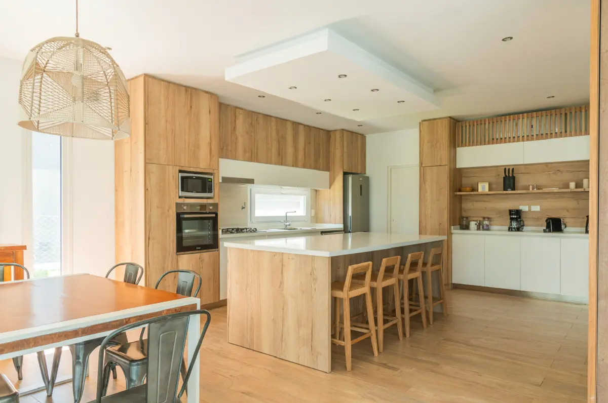 Cozinha moderna com ilha de madeira e sala de jantar integrada — projeto Reforma cocina, por Metro creativo, em Belén de Escobar
