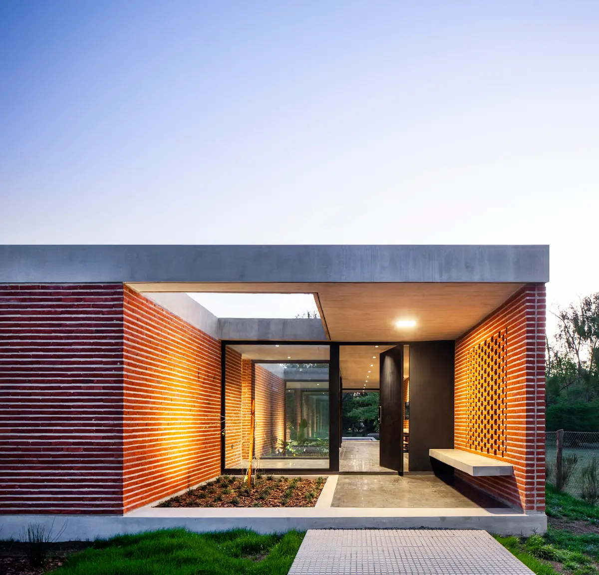 Fachada moderna com tijolo aparente e concreto — projeto Casa FLOIG, por V2 Arquitectos, em Villa Elisa