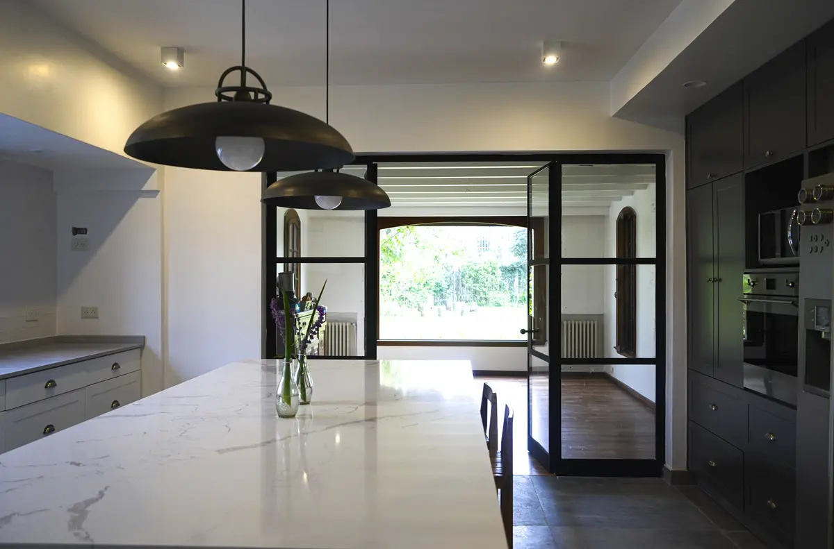 Cozinha moderna com ilha de mármore e grandes janelas — projeto Obra Isabel la Católica P, por Arq. Lourdes Yarade Saravia, em San Isidro