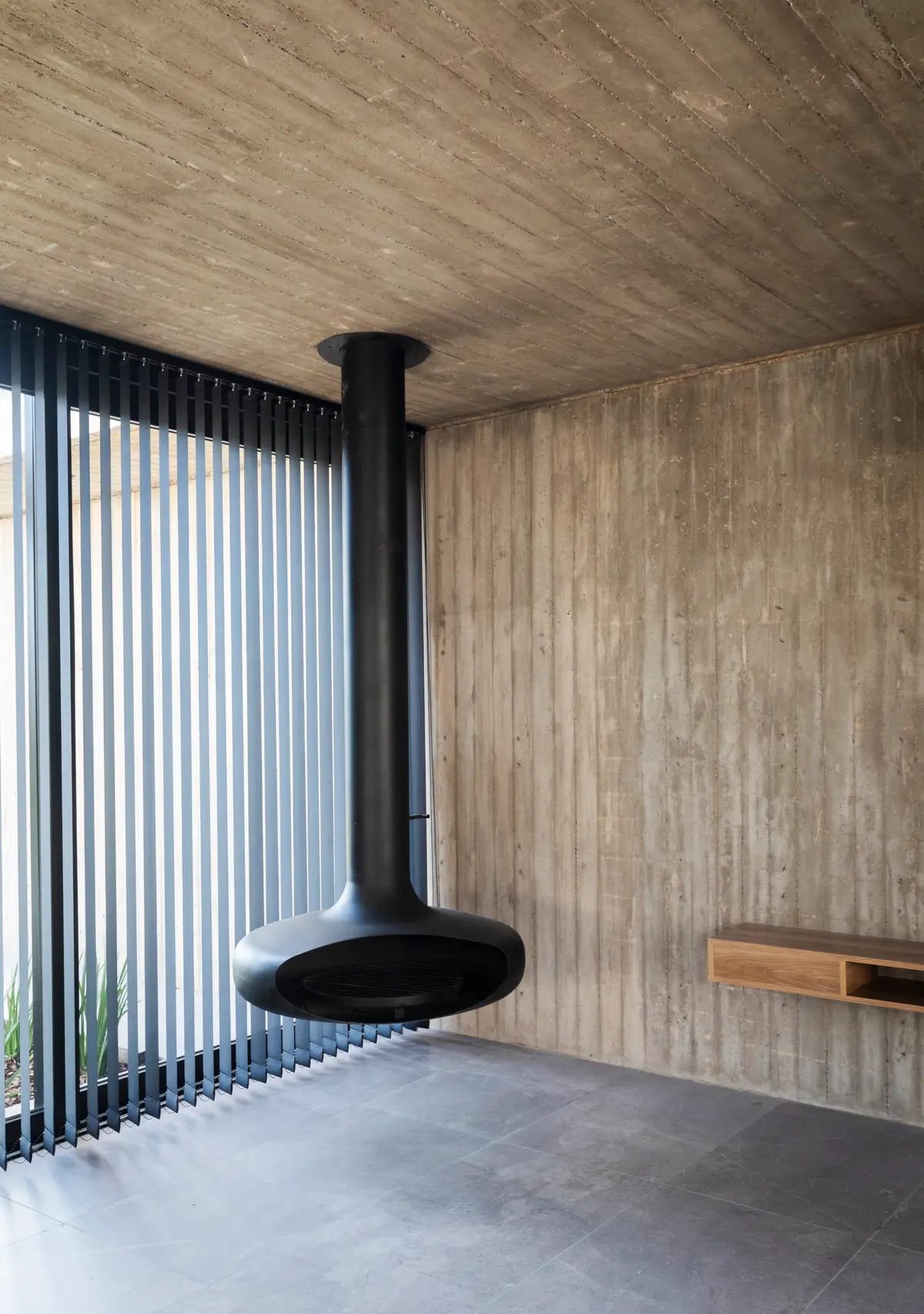 Sala de estar moderna com lareira suspensa e paredes de concreto — projeto Casa ROMA, por V2 Arquitectos, em City Bell