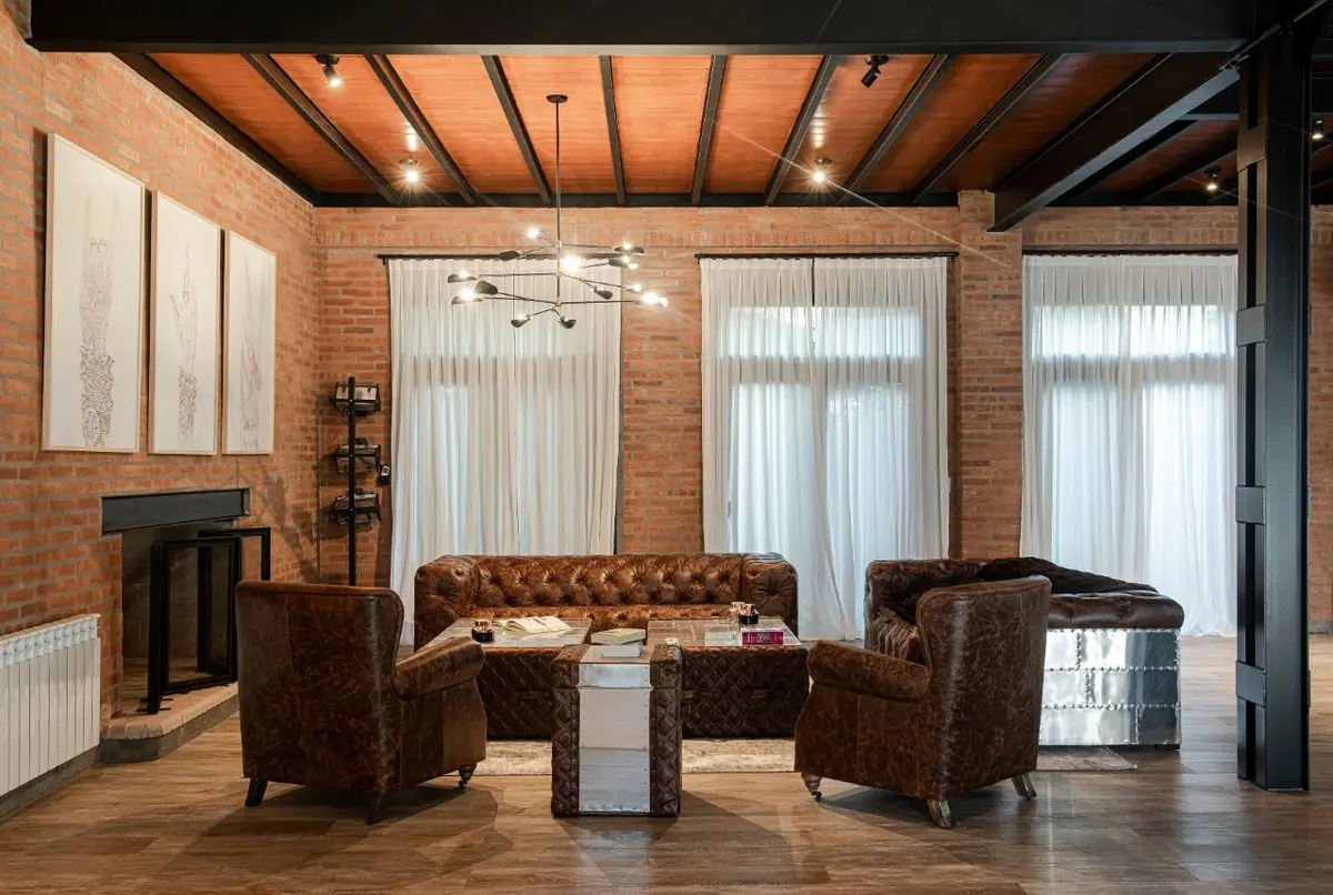 Sala industrial com tijolo aparente e couro — projeto Loft y garage autos de colección, por Arq. Damian Fainzilber, em San Isidro