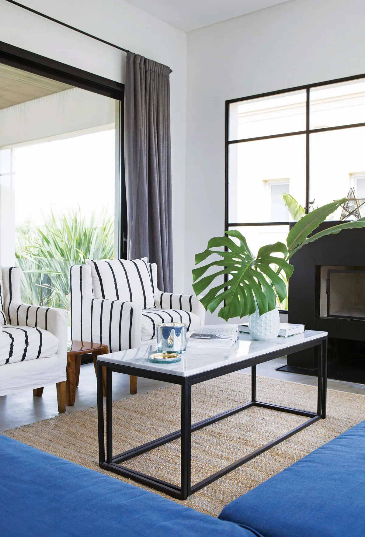 Sala de estar moderna com poltronas listradas e muita luz natural — projeto Casa Las Liebres, por Mazzinghi Sanchez, em Garin
