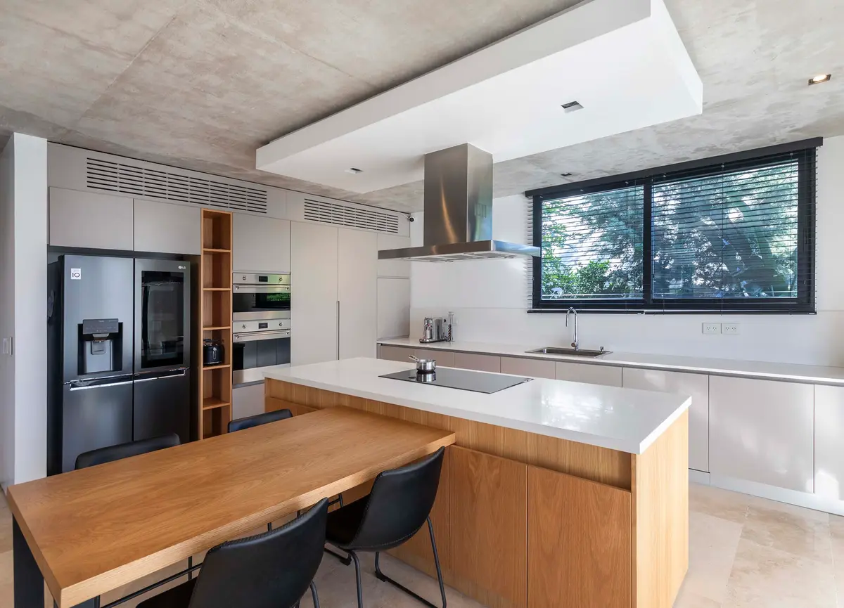Cocina moderna de concepto abierto con isla grande y techo de hormigón — proyecto Serra Golf - Estudio Remy, por ABEJA CONCEPT, en Avenida del Golf s/n