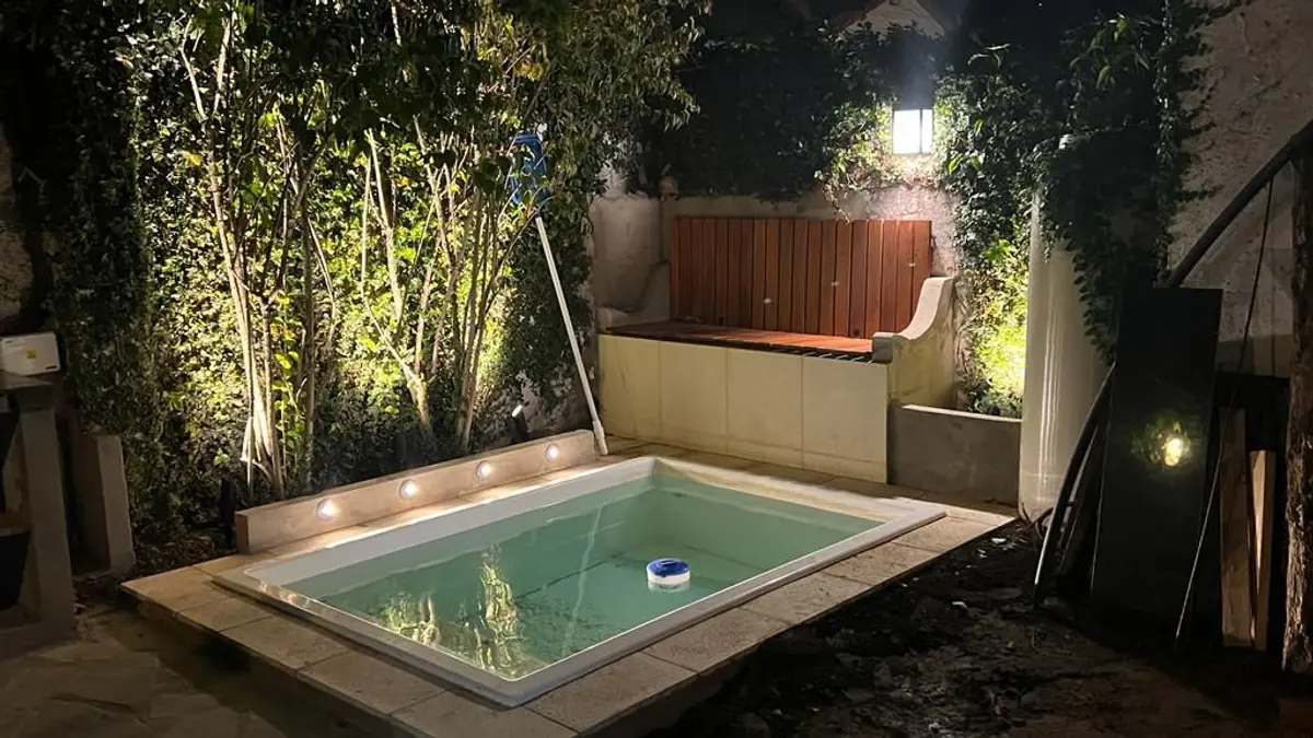 área de piscina moderna con jardín vertical y deck de madera — proyecto Don Bosco , por MC Deco , en San Isidro