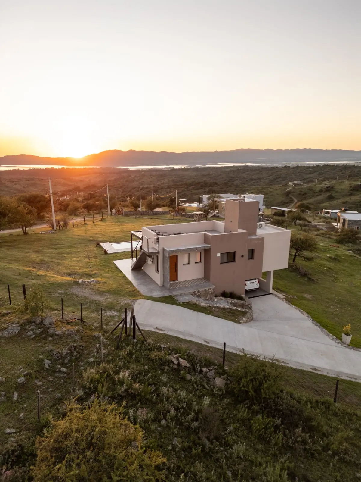 Casa moderna em encosta com piscina infinita ao pôr do sol — projeto Complejo de Cabañas en Potrero de Garay, Córdoba, por ESTUDIO ARQ.GABRIEL ARIAS, em Córdoba