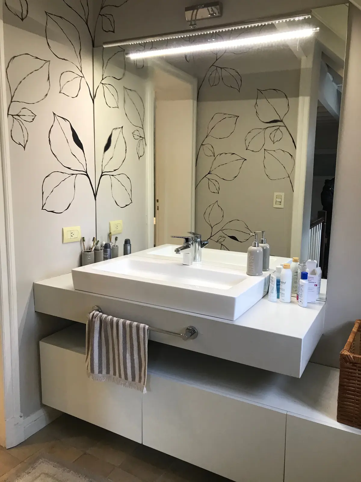 Baño moderno con mesada blanca, espejo iluminado y decoración minimalista — proyecto Casa en Martinez, por Rioja Arquitectura, en Martínez